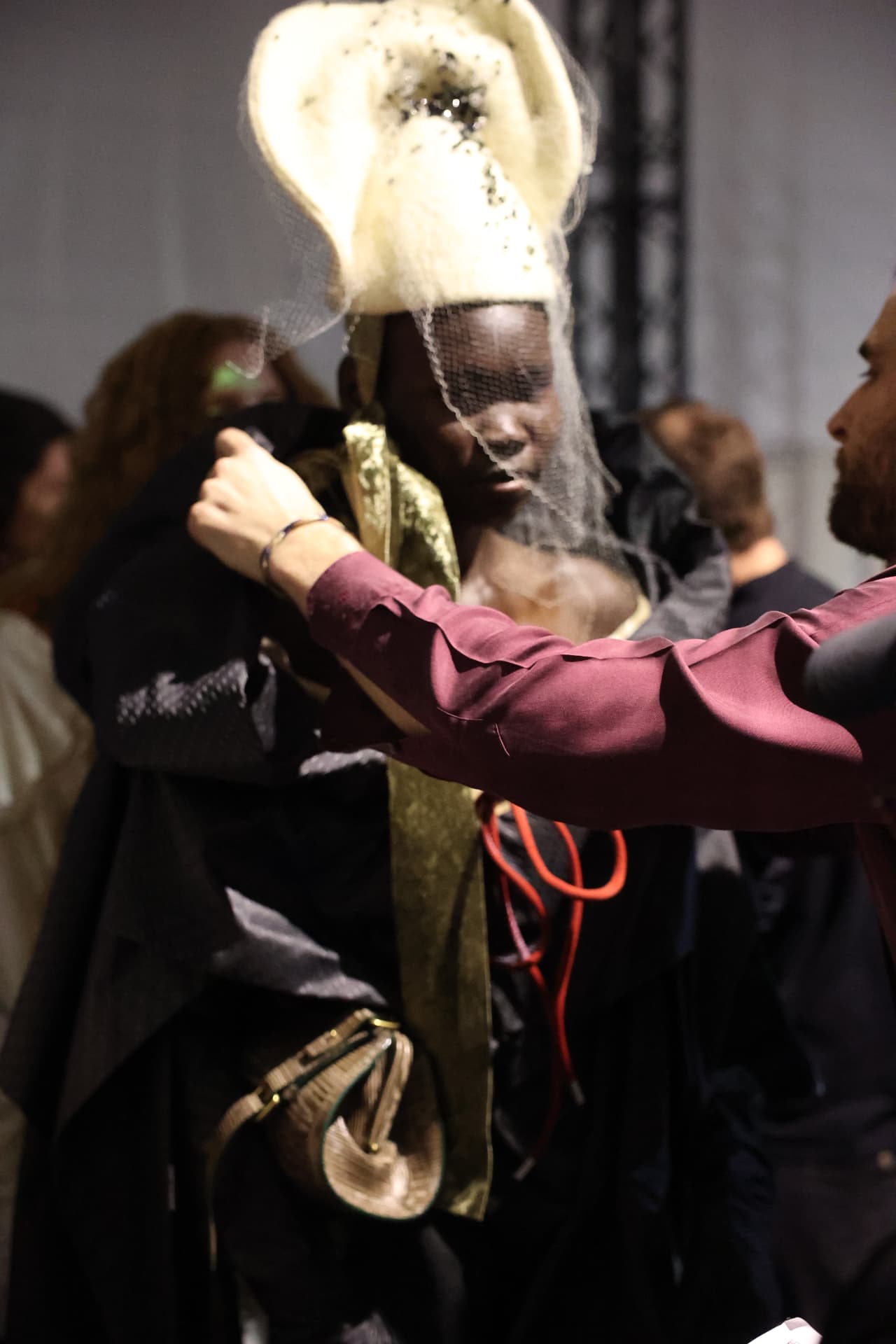 Model having hair prepared backstage in front of a mirror