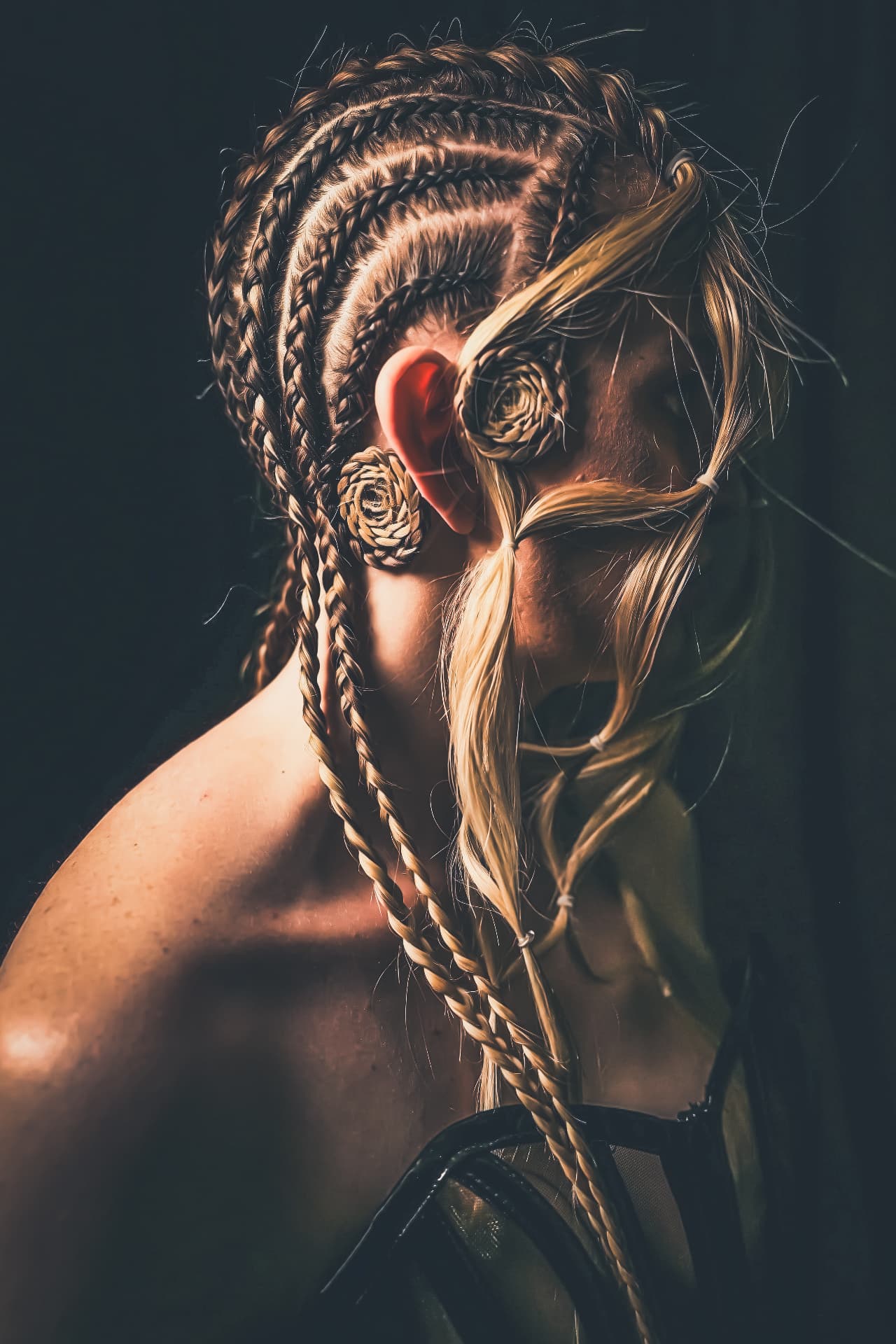 Profile view of cornrow braids finished with coiled rosette shapes